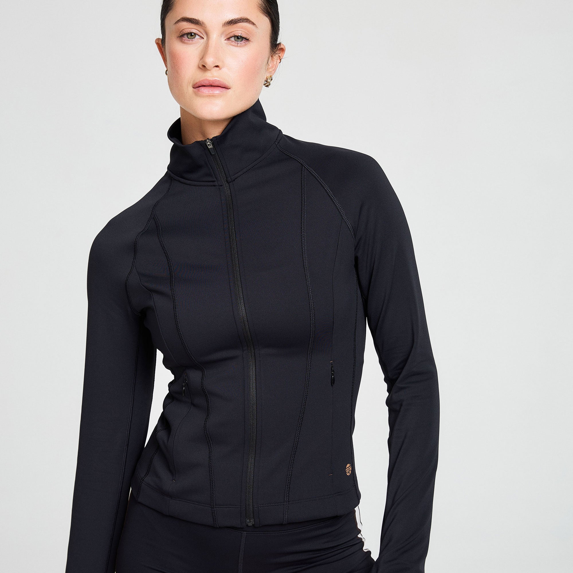 Black Attune jacket zipped up showing detail of contour design and stitiching