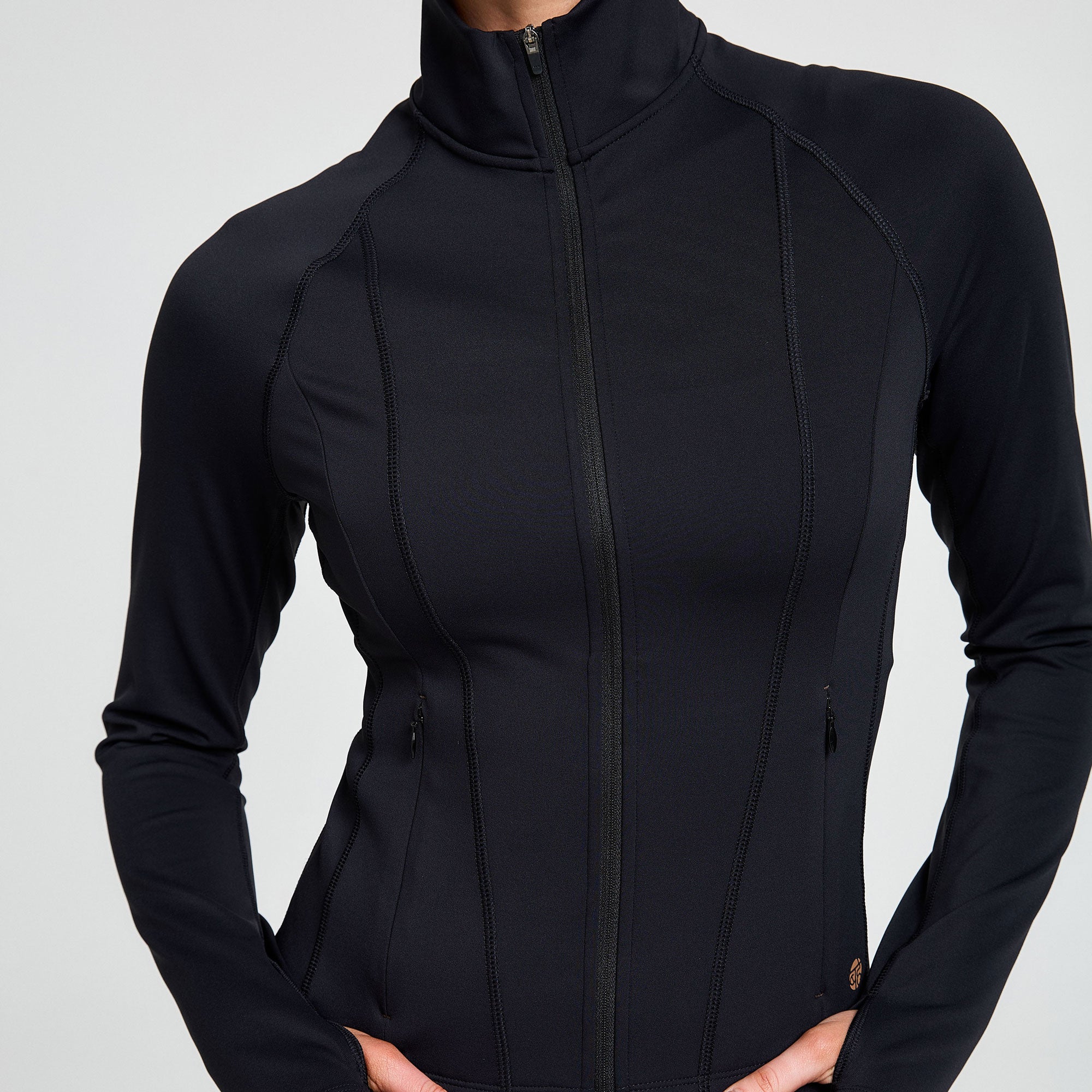 A black Attune seamed zip through jacket with a slightly higher neckline and visible zip closure at the front.